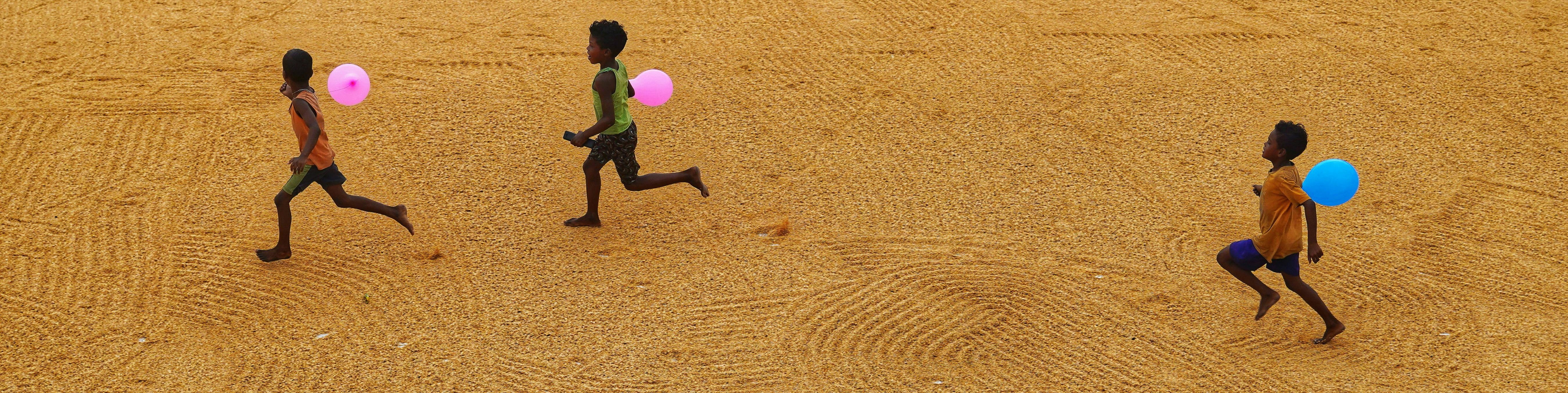 Lapset juoksee ilmapallot käsissä.
